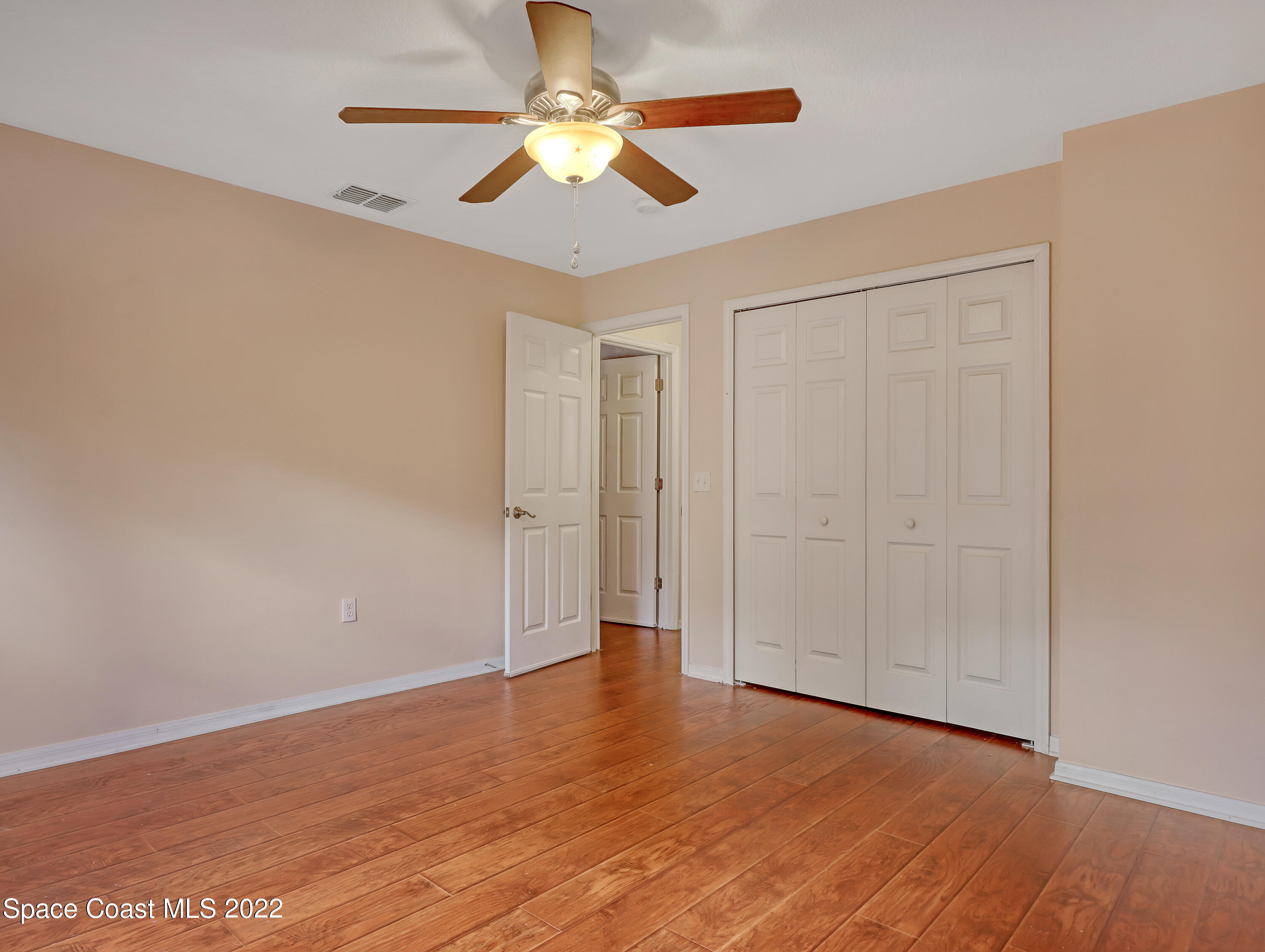 4764 Doreen Road Cocoa, FL 32927 - Photo 36 of 54 an empty room with wooden floor fan and windows