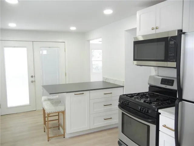 a kitchen with granite countertop a stove and a microwave