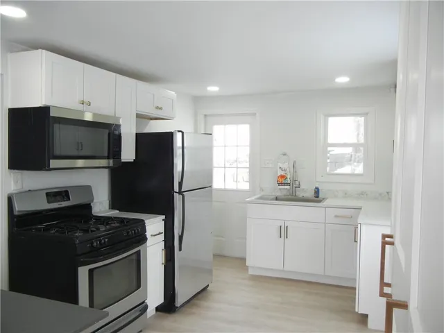 a kitchen with a sink stainless steel appliances and cabinets