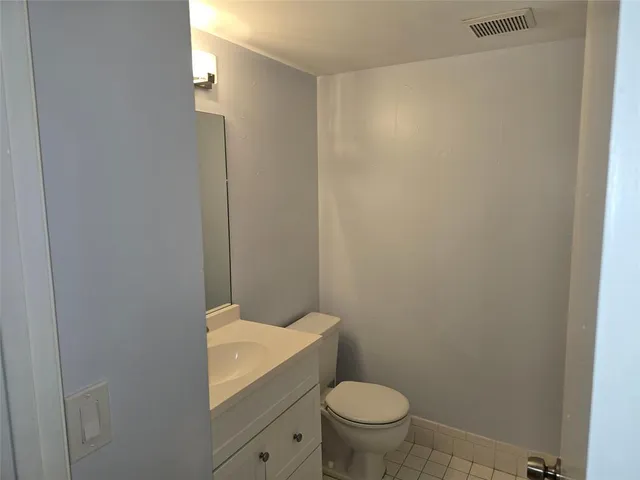a bathroom with a granite countertop toilet and a sink