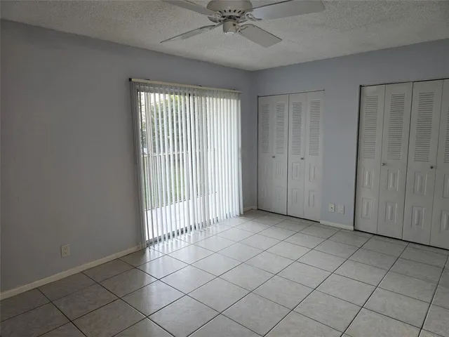 a view of a livingroom with a chandelier fan and windows