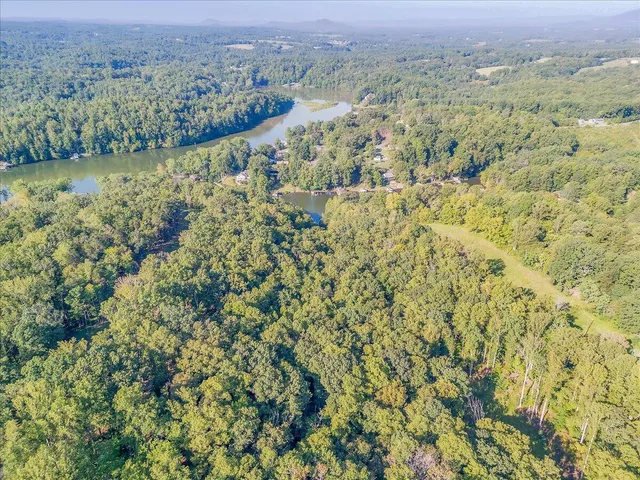 an aerial view of residential houses with outdoor space and lake view