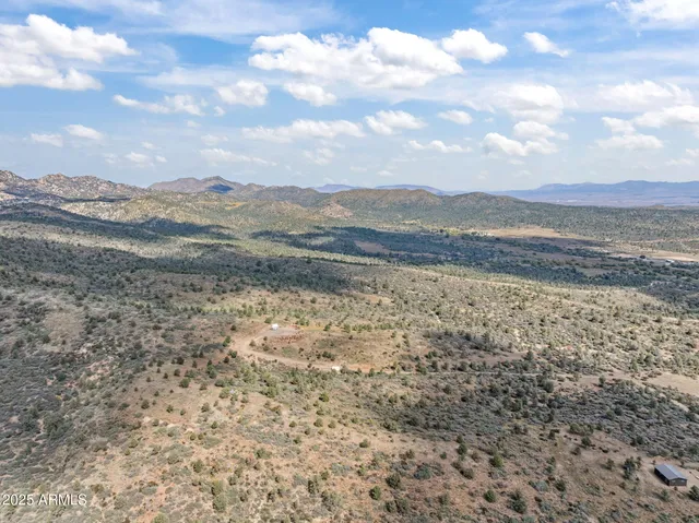 a view of a dry yard with mountains in the background
