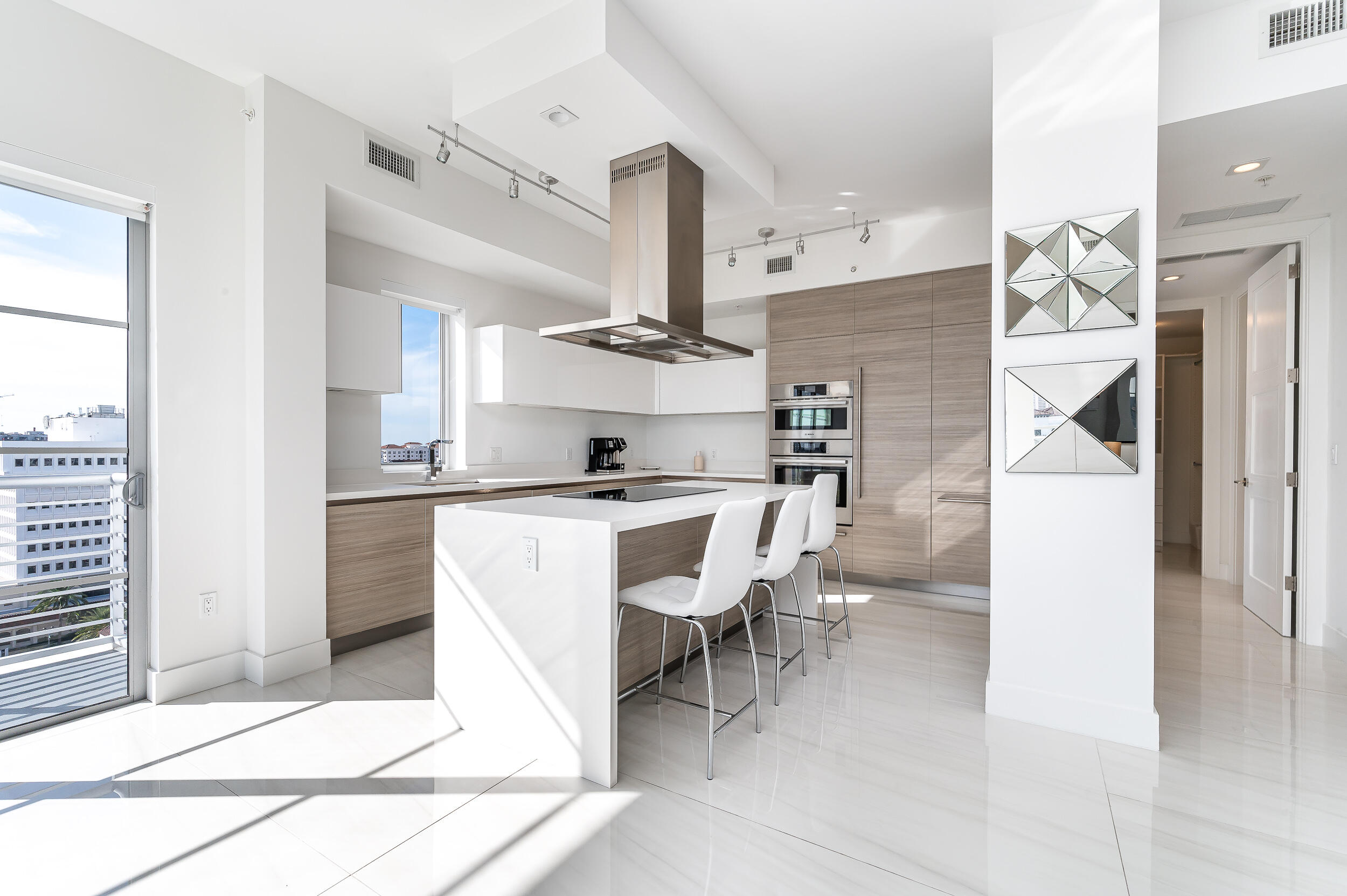 155 East Boca Raton Road, Unit 1103 Boca Raton, FL 33432 - Photo 5 of 57 a kitchen with stainless steel appliances kitchen island a table chairs in it and white cabinets