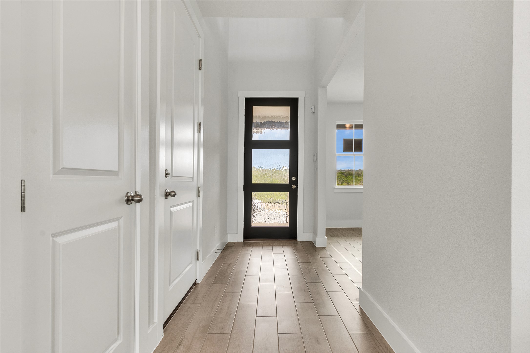 8500 Red Bottle Brush Road Lago Vista, TX 78645 - Photo 2 of 33 A welcoming entryway with sleek wood flooring and a modern door awaits residents.
