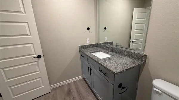 a bathroom with a granite countertop sink and a mirror
