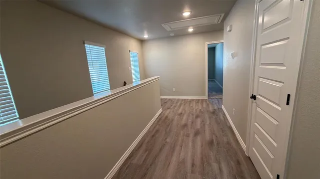 a view of a hallway with wooden floor and staircase