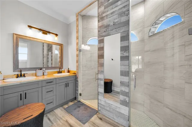 a bathroom with a double vanity sink toilet and shower