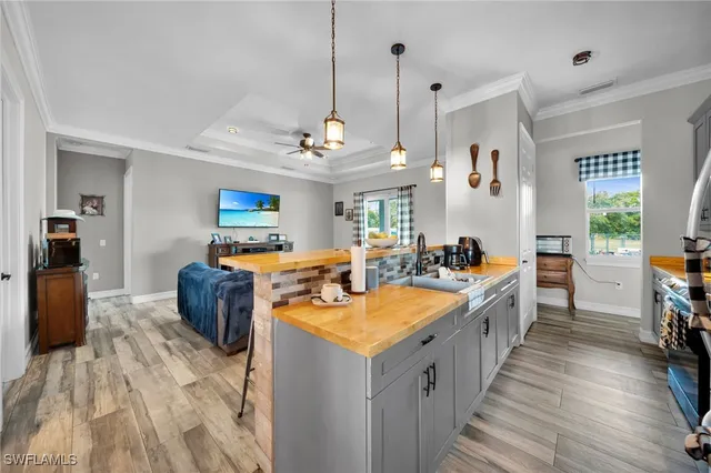 a large white kitchen with sink a refrigerator and chairs