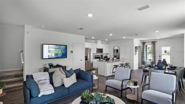 a living room with furniture kitchen and a table