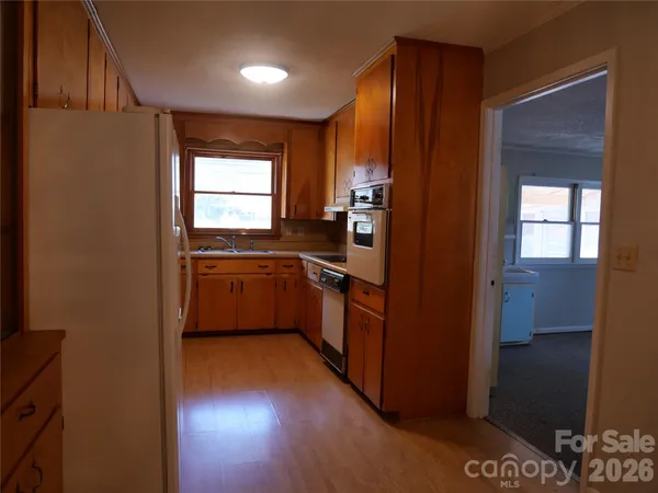a kitchen with a sink cabinets stainless steel appliances and a window