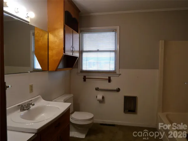 a bathroom with a sink toilet and mirror