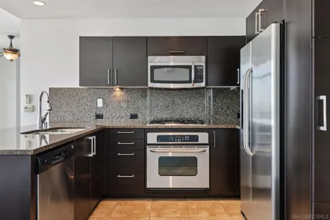 a kitchen with stainless steel appliances granite countertop a refrigerator and a stove top oven