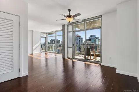 a view of an empty room with wooden floor and window