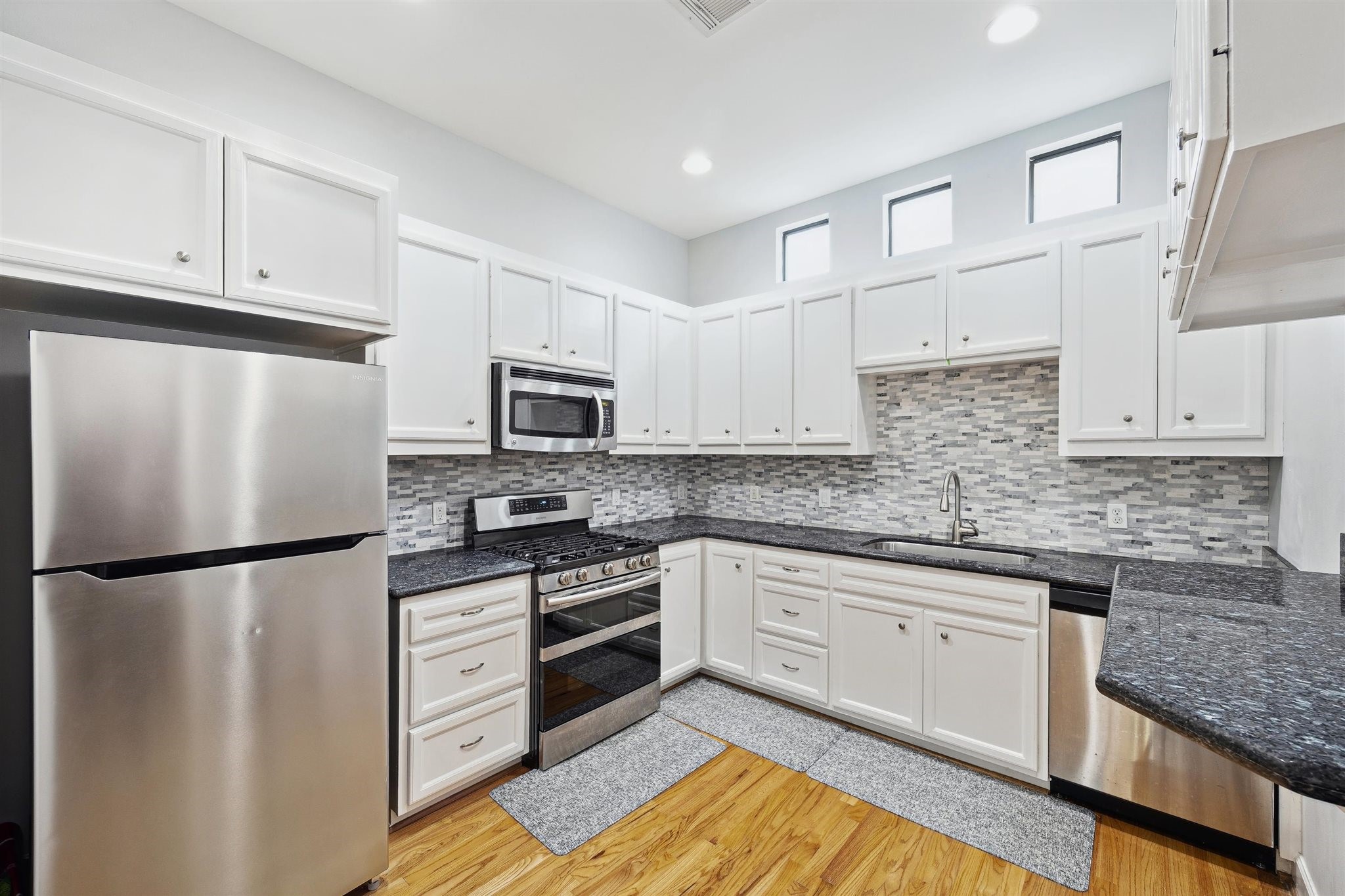 11315 South Main Street, Unit 1401 Houston, TX 77025 - Photo 2 of 14 a kitchen with stainless steel appliances granite countertop a refrigerator sink stove and white cabinets