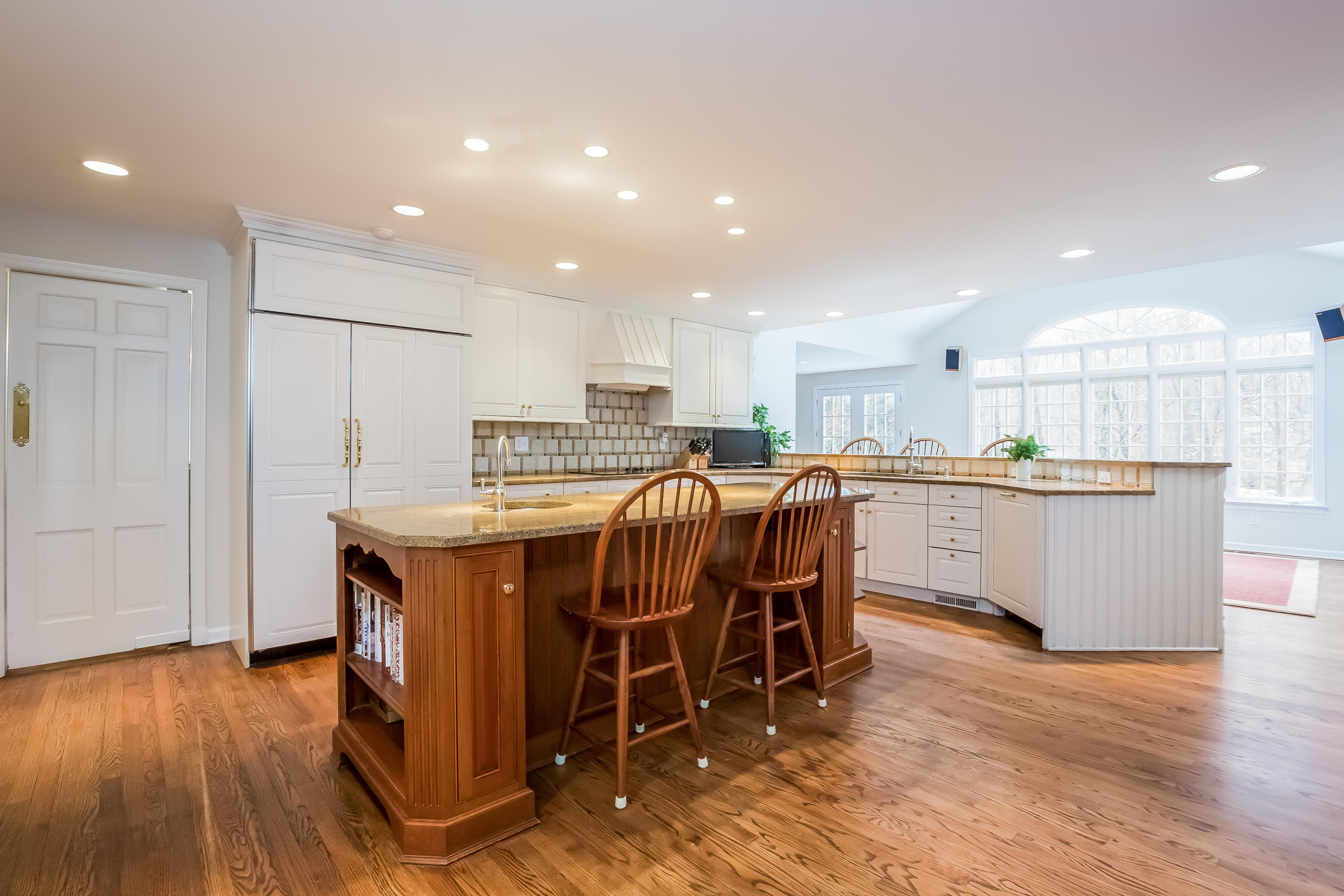 132 Colony Road Darien, CT 06820 - Photo 7 of 25 a kitchen with stainless steel appliances kitchen island granite countertop a table chairs sink refrigerator and cabinets