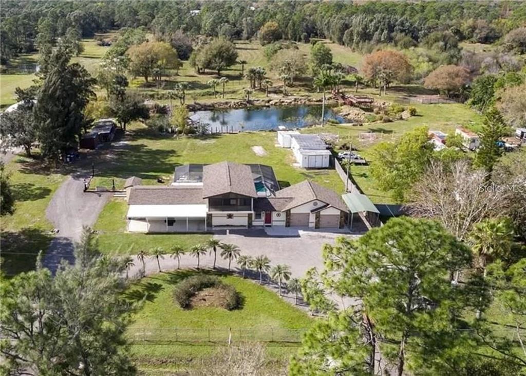 an aerial view of a house with yard swimming pool and lake view