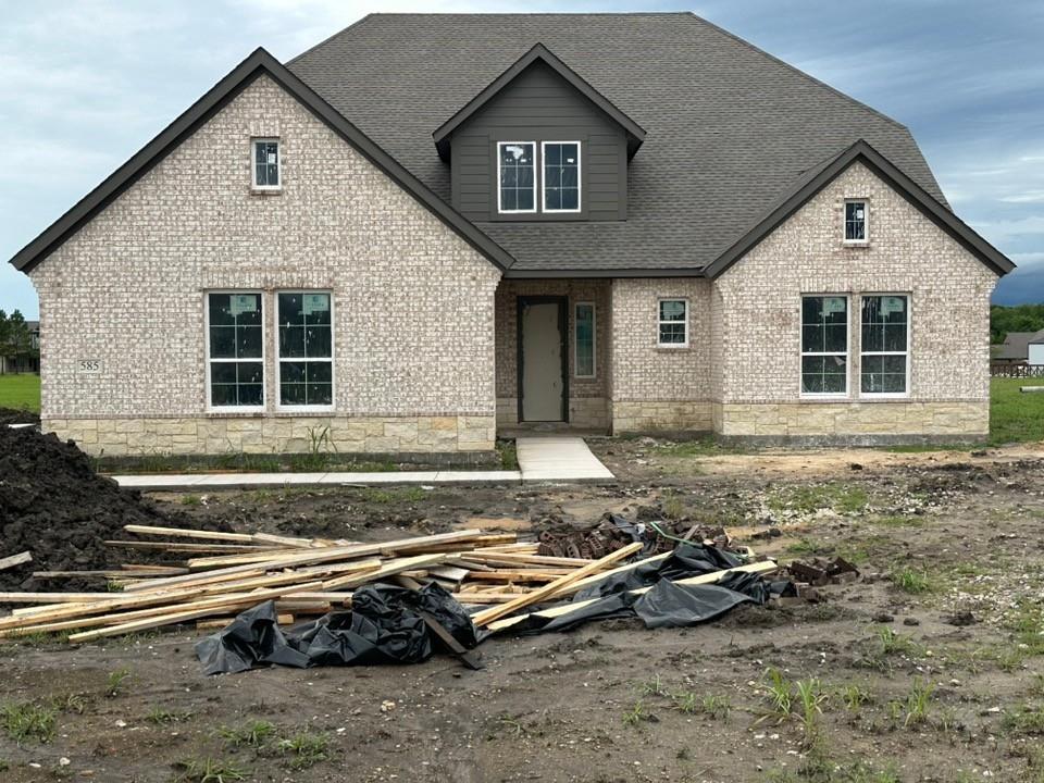585 Brown Road Leonard, TX 75452 - Photo 2 of 29 Exterior featuring light-colored brick, stone accents, dark gables, an asphalt shingle roof, and multiple windows