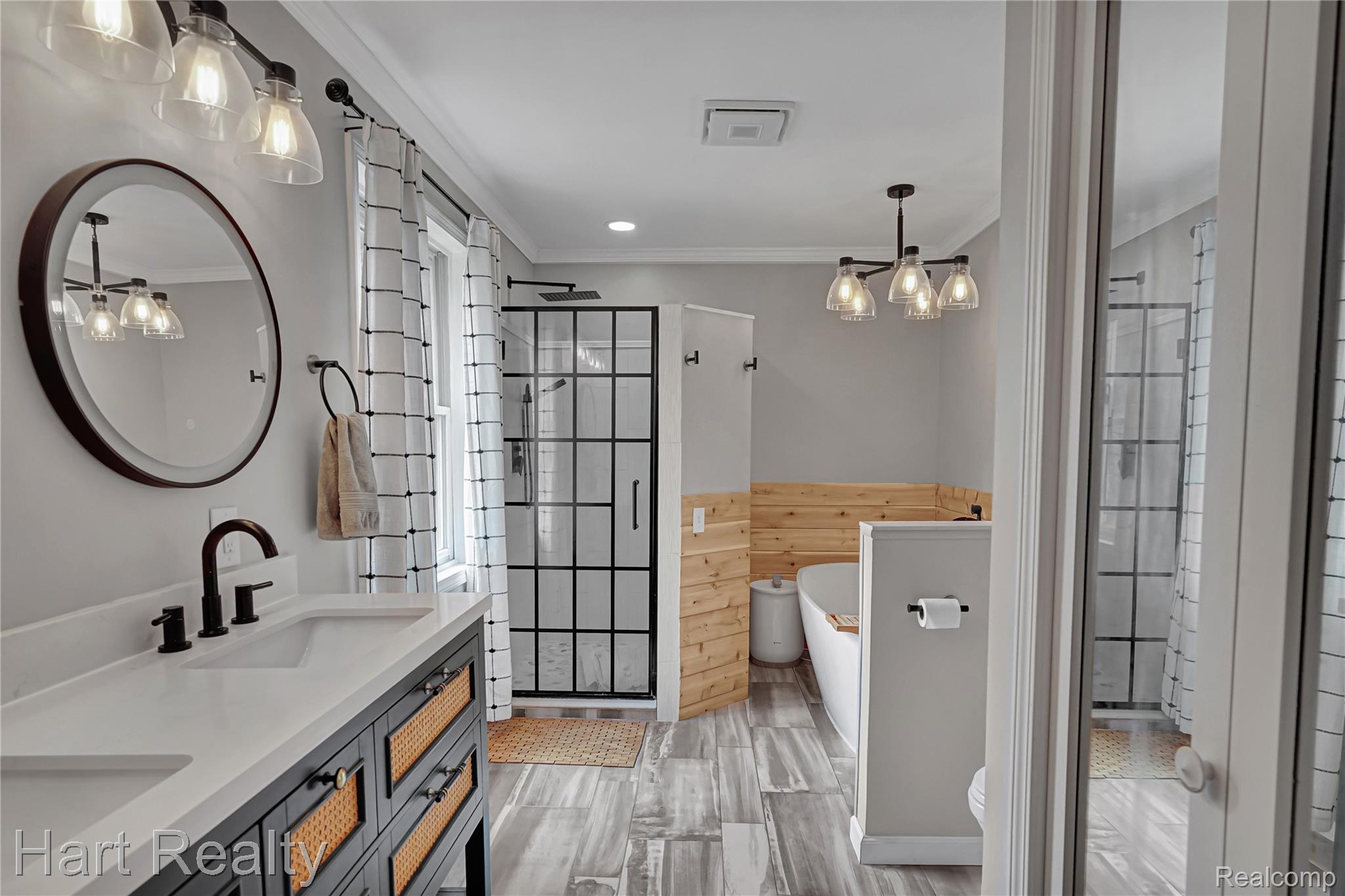 7167 Brown School Road North Branch, MI 48461 - Photo 25 of 51 Bathroom featuring a modern double vanity with woven paneling, a standalone soaking tub, and a glass-enclosed shower with a grid pattern