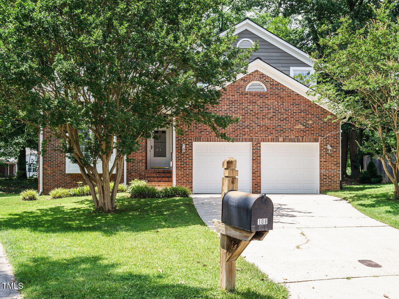 a backyard of a house with garden and outdoor seating