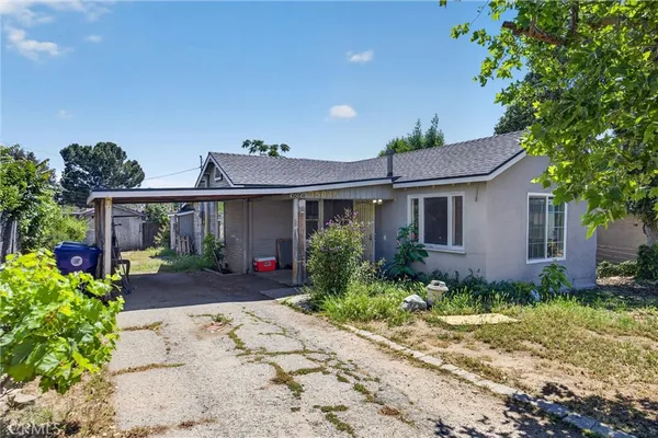 a front view of a house with a yard and potted plants