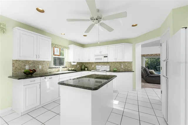 a kitchen with granite countertop a sink a counter top space and cabinets
