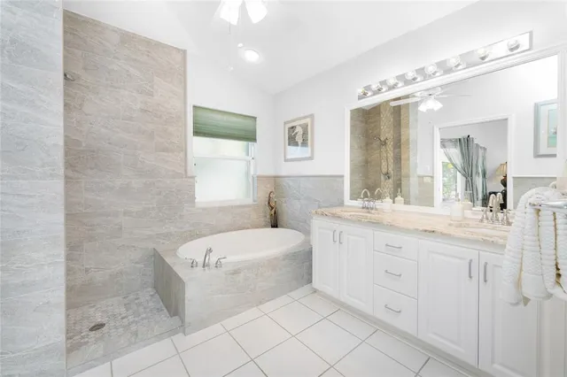 a spacious bathroom with a double vanity sink mirror and bathtub