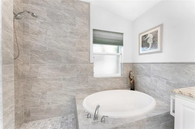 a bathroom with a white tub and a window