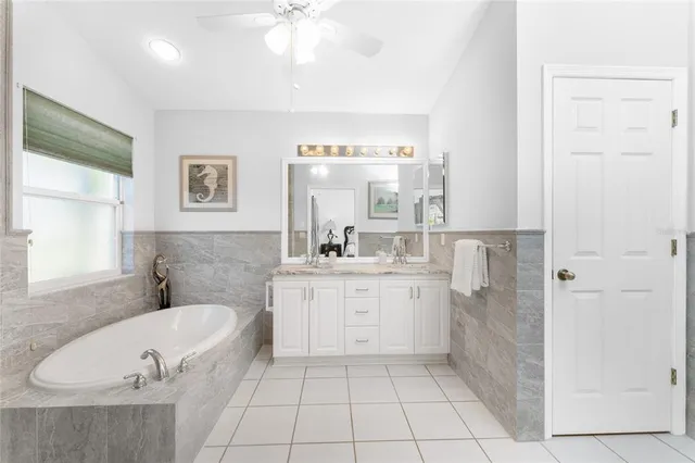 a bathroom with a tub sink and mirror
