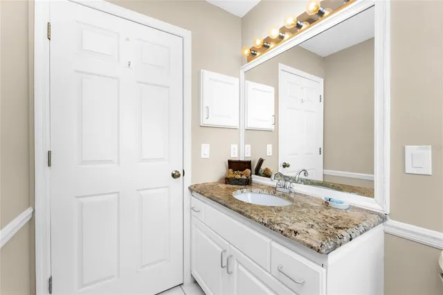 a bathroom with a granite countertop sink and a mirror