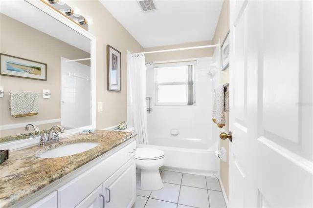 a bathroom with a granite countertop sink a toilet and shower