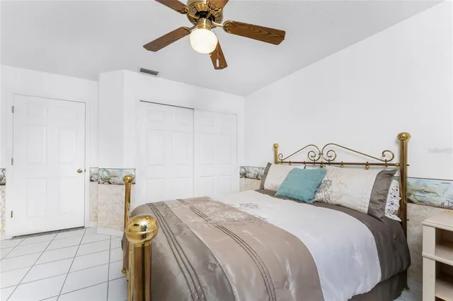 a bedroom with a bed and a ceiling fan