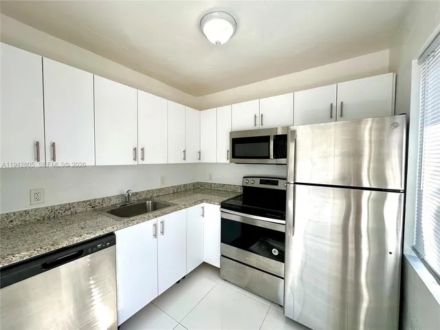 a kitchen with stainless steel appliances a refrigerator sink and microwave