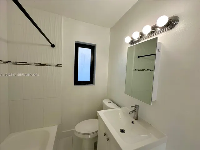 a bathroom with a sink mirror and toilet