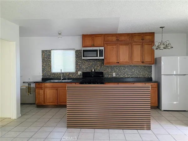 a kitchen with stainless steel appliances granite countertop a sink and a refrigerator