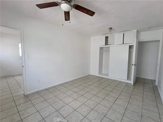 an empty room with closet and windows