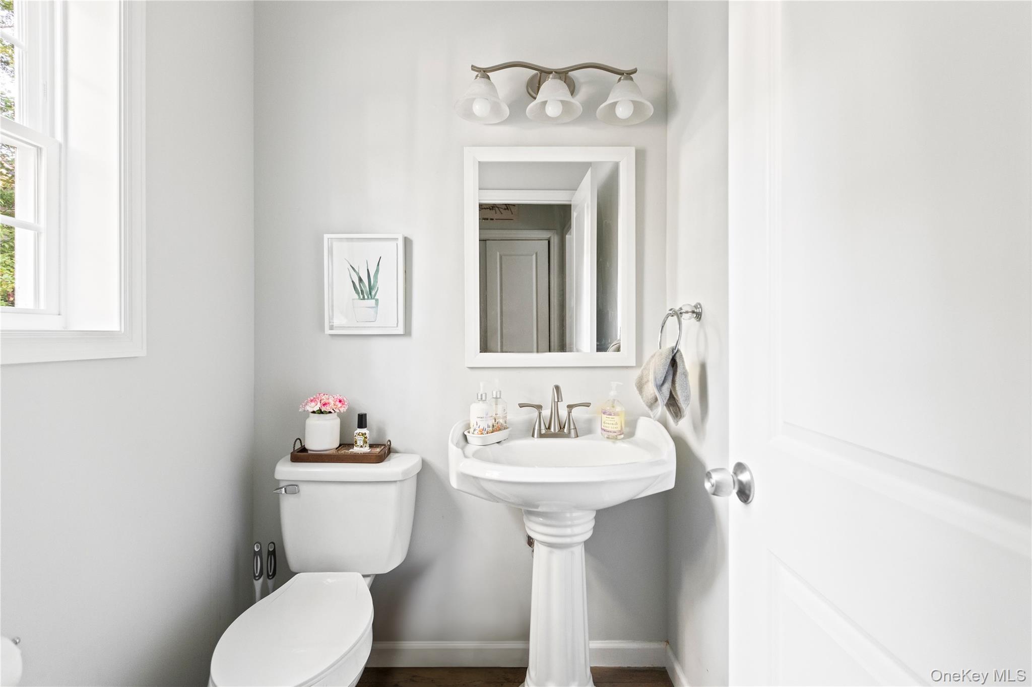 24 Belmont Road Sound Beach, NY 11789 - Photo 7 of 23 a bathroom with a toilet sink and mirror