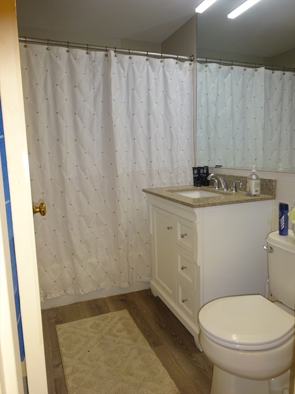 1321 Worcester Road, Unit 610 Framingham, MA 01701 - Photo 12 of 30 a bathroom with a granite countertop sink toilet and a mirror