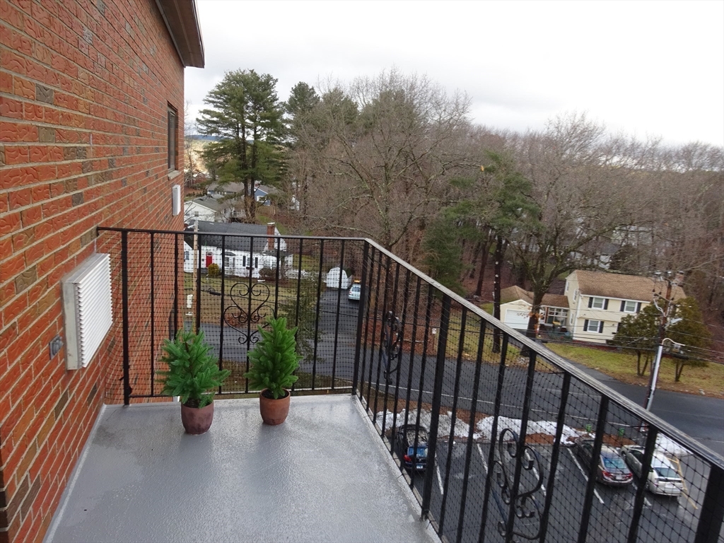 1321 Worcester Road, Unit 610 Framingham, MA 01701 - Photo 21 of 30 a view of a balcony with chairs and wooden fence