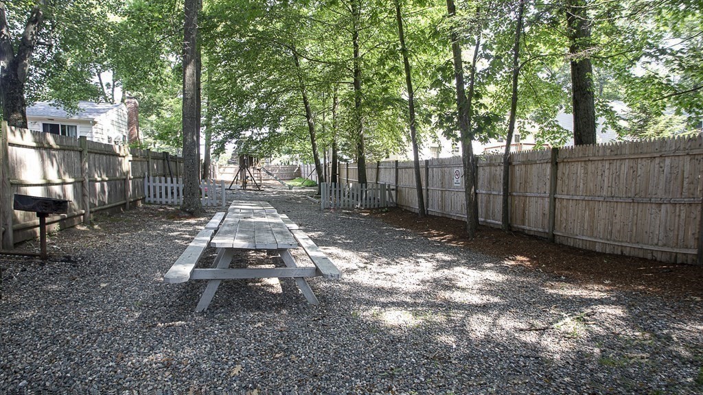 1321 Worcester Road, Unit 610 Framingham, MA 01701 - Photo 30 of 30 a view of a backyard with large trees and wooden fence