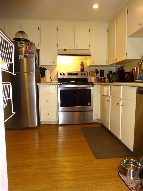 1321 Worcester Road, Unit 610 Framingham, MA 01701 - Photo 4 of 30 a kitchen with granite countertop a refrigerator stove and white cabinets