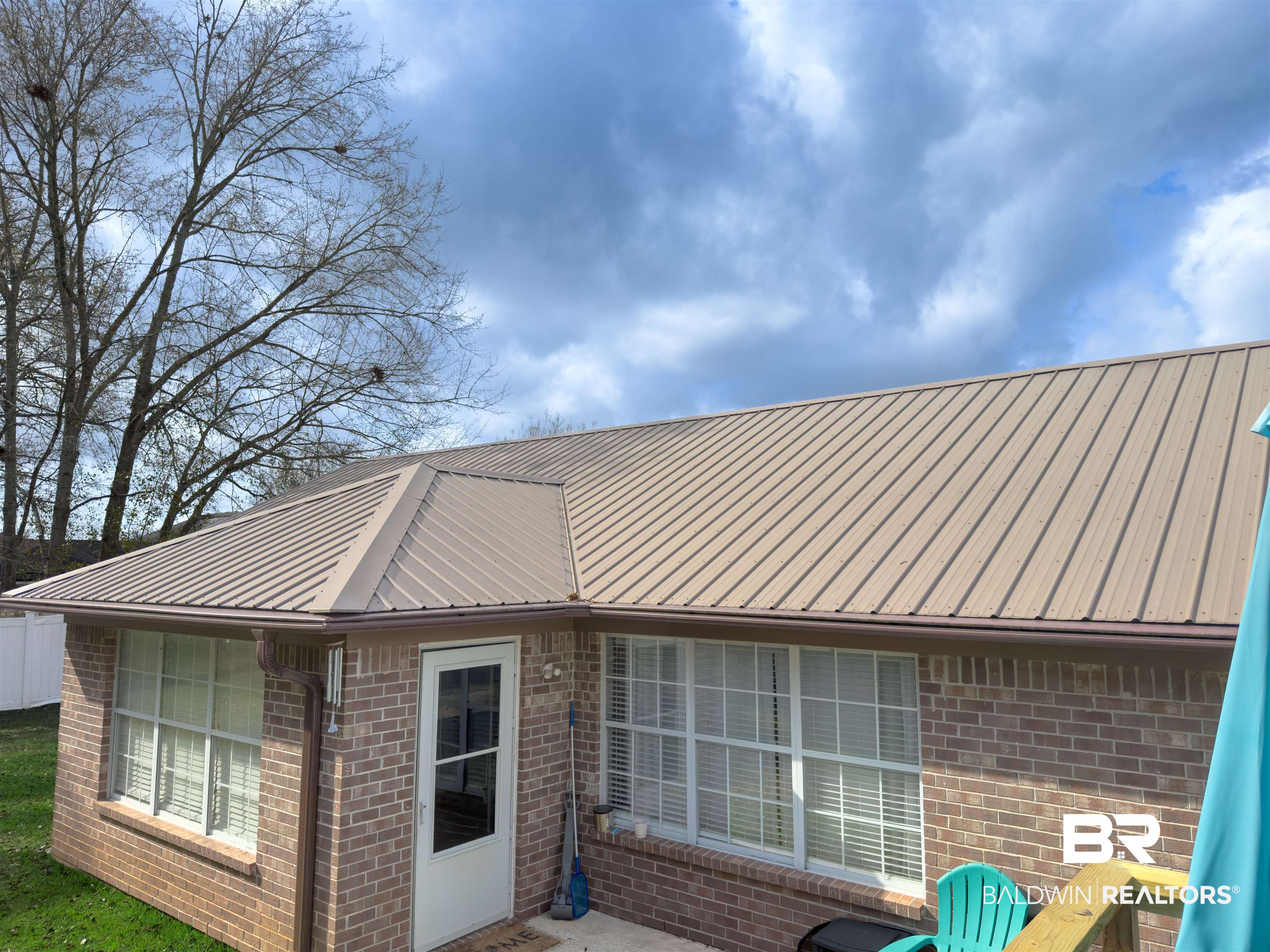 129 Pennbrooke Loop Foley, AL 36535 - Photo 44 of 44 Rear view of house with brick siding, a metal roof, and a patio