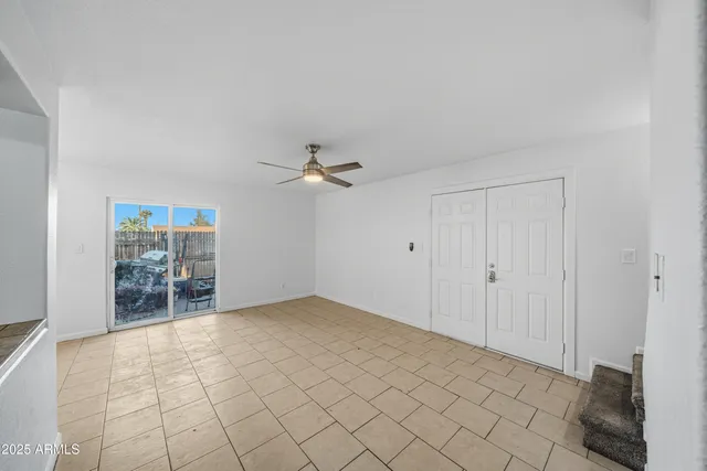 a view of a room with a ceiling fan and entryway