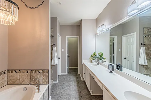 a spacious bathroom with a tub sink and mirror