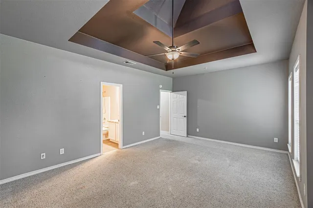en empty room with ceiling fan and window