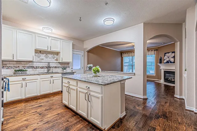 a kitchen with granite countertop a sink and cabinets