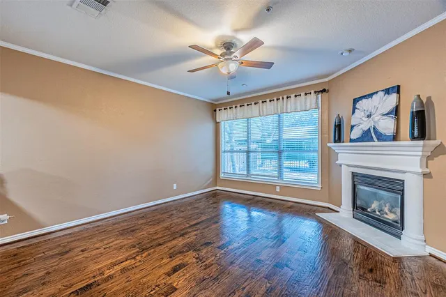 a view of an empty room with a fireplace and a window