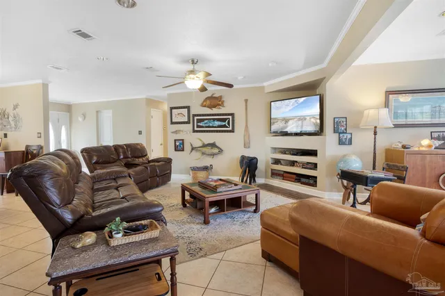 a living room with furniture a flat screen tv and kitchen view