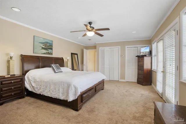 a spacious bedroom with a bed and a ceiling fan