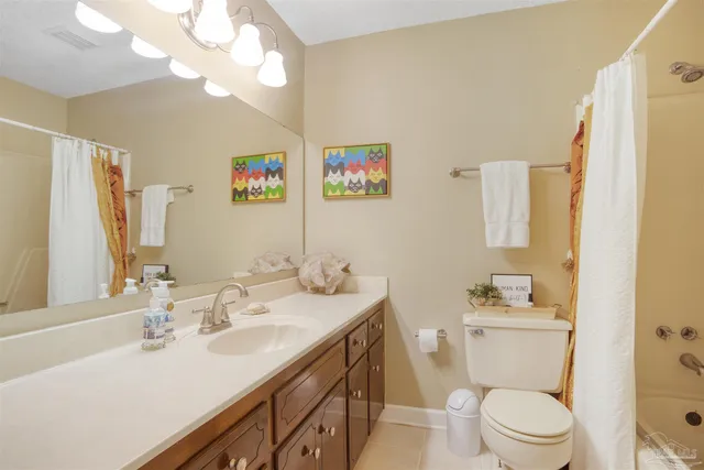 a bathroom with a sink a toilet a mirror a vanity and shower
